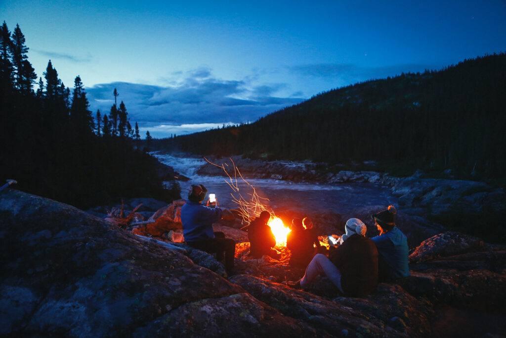 Campers gathered around a campfire on the Magpie River
